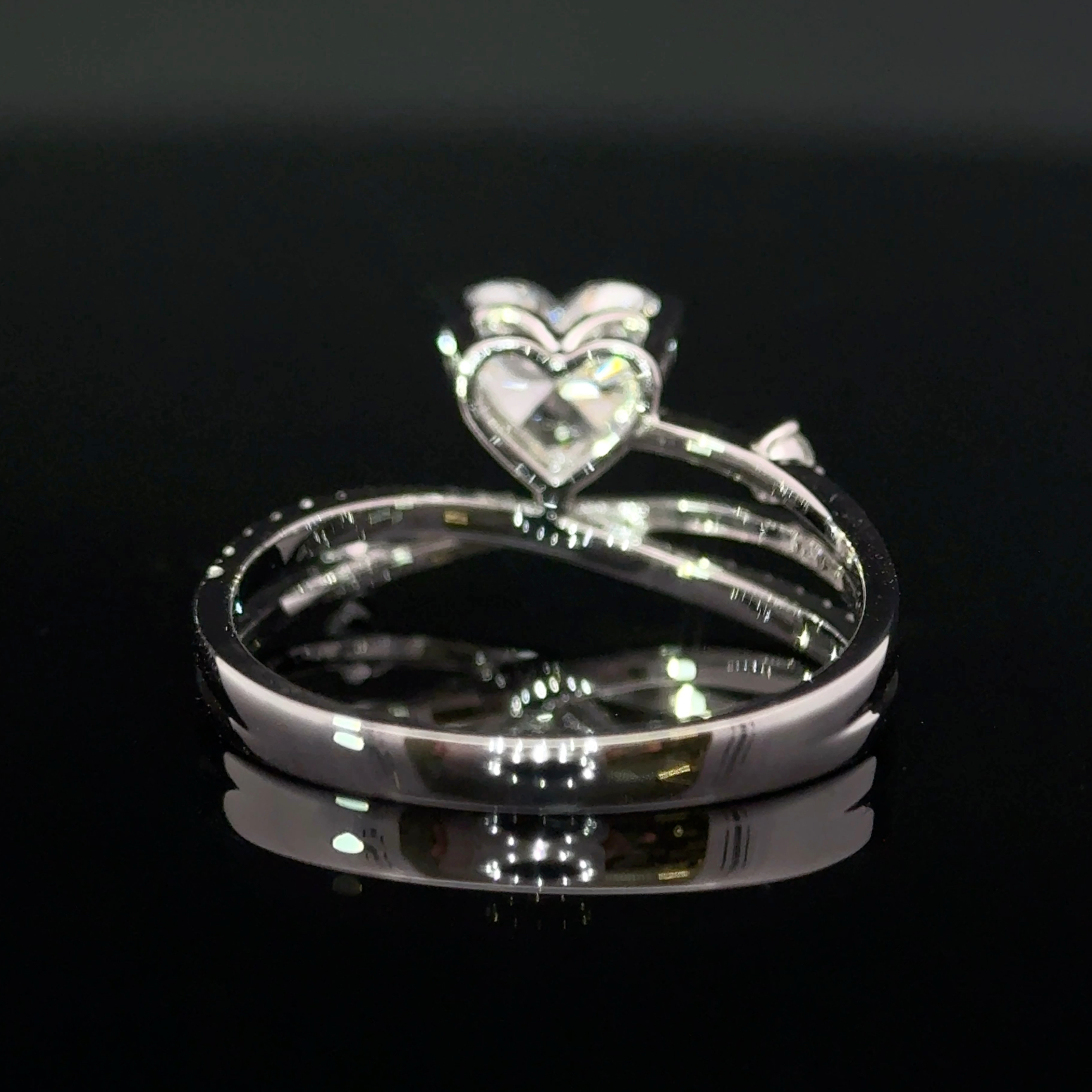 Rear view showing the heart-shaped basket and layered polished bands of the ring